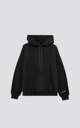 Hoodie negro de frisa premium, corte oversize, con capucha ajustable y puños y cintura elastizados. Presenta un bolsillo canguro frontal y un detalle de etiqueta tejida con texto repetido en los cordones de la capucha y en la manga izquierda.