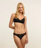 Bombacha de bikini tipo bikini, color rosado, confeccionada en encaje floral con terminación de encaje festoneado en los bordes.