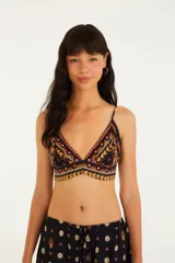 Top negro con estampado de pañuelo en tonos naranja, amarillo y rosa. Tiene tirantes finos regulables y corte triangular.