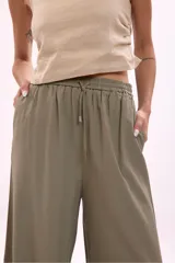 Pantalón palazzo negro de tiro alto con cintura elastizada y cordón ajustable.