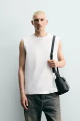 Camiseta sin mangas de corte relajado, con cuello redondo y diseño liso en color blanco.