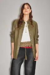 Camisa de cuero ovino color verde oliva, con cuello clásico, cierre frontal con botones y mangas largas con puños abotonados. Presenta un corte holgado y diseño tipo sobrecamisa.