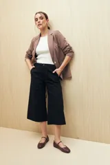 Pantalón capri negro acampanado de algodón con inspiración cargo, corte amplio y bolsillos laterales.