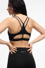 Top deportivo de microfibra en color beige con detalles de ribetes y banda inferior en color marrón. Presenta diseño de espalda estilo nadadora y logo de la marca estampado en la banda elástica inferior.