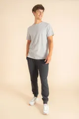 Pantalon deportivo de corte jogger, color gris oscuro, con cintura elástica y puños acanalados en los tobillos.