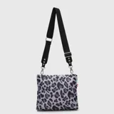 Bolso tipo tote mini con diseño estampado de leopardo en tonos grises y negros. Cuenta con una correa larga ajustable y extraíble de color negro con detalles metálicos y logo de la marca.