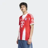 Camiseta de fútbol Adidas del FC Bayern Múnich, modelo Home 25/26. Diseño rojo y blanco con efecto distorsionado que revela la letra M. Cuenta con tejido transpirable AEROREADY y escudo del club bordado.