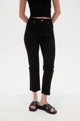 Pantalón jean de tiro alto y corte recto, color blanco, con bolsillos laterales y traseros, y terminación desmechada en los tobillos.