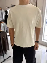 Remera color crudo de corte boxy fit, con mangas cortas y cuello redondo.