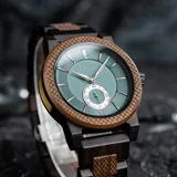 Reloj de pulsera Chenaut modelo Émeraude d’Ébène, con caja y malla de madera de ébano y nogal. Esfera verde esmeralda con segundero pequeño. Cristal Hardlex y movimiento de cuarzo. Resistente al agua (3 ATM).