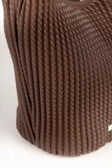 Cartera tipo hobo de color negro, con diseño plisado en toda su superficie y correa ajustable con hebilla metálica. Presenta una placa metálica decorativa en la parte inferior frontal.