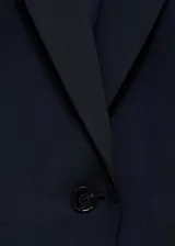 Blazer entallado de color azul marino con cuello de solapa con muesca, hombros estructurados y cierre frontal de un botón. Presenta diseño recto con pinzas, dos bolsillos de ribete delanteros y abertura posterior.