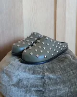 Zuecos negros de cuero vegano con tachas plateadas.