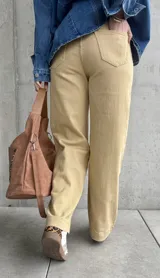 Pantalón de jean color beige, de corte recto y tiro alto, con bolsillos delanteros y traseros.