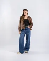 Campera cropped tipo bomber color marrón con acabado vintage, capucha con cordón ajustable, cierre frontal y puños y ruedo elásticos.