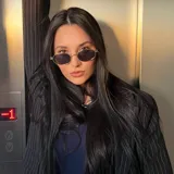 Lentes de sol con armazón metálico dorado de forma ovalada y cristales oscuros con protección UV400.