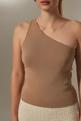 Top sin mangas de tejido liso, corte al cuerpo, con escote asimétrico de un solo hombro.