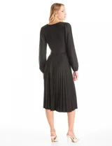 Vestido midi negro de seda fría con escote en V decorado con aplique de guipur y lazo central. Presenta mangas largas fluidas con puños fruncidos, hombros con leves frunces y cintura ajustable con lazo que da paso a una falda plisada.