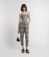 Pantalón zanahoria de sastrería con estampado de cuadros, bolsillos laterales, botón en la cintura y cierre por botón y cremallera.