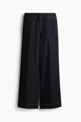 Pantalón de jean estilo wide leg, de tiro alto y corte holgado. Confeccionado en denim rígido de color azul oscuro, presenta costuras a contratono, bolsillos laterales al bies y bolsillos traseros decorativos.