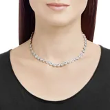 Collar de eslabones con engaste de cristales redondos engarzados en pavé, cada uno con un cristal central más grande. El metal tiene un baño de rodio.