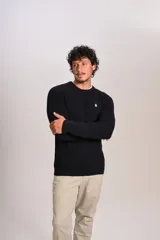 Sweater de punto grueso con cuello redondo, manga larga y puños acanalados. Presenta un pequeño logo bordado en el pecho.
