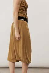 Pantalón holgado negro tipo bombacho, con cintura elástica y puños fruncidos en los tobillos.