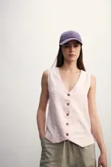 Chaleco sin mangas de corte sastrero, color rosa claro, con escote en V y cierre frontal con botones a tono.