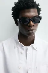 Camisa de corte regular fit confeccionada en tejido de algodón con diseño de rayas verticales. Presenta cuello abotonado, manga larga con puños abotonados, bolsillo plastrón en el pecho y cierre frontal con botones.