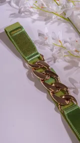 Cinto elastizado color verde con aplique de cadena dorada.
