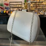 Clutch plateado brillante de eco cuero, con asa de cadena desmontable plateada.