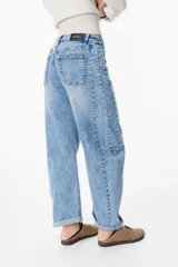 Jean de corte wide leg en color azul lavado, con tiro medio, cierre frontal con botón y bolsillos laterales y traseros.