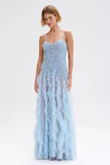 Vestido largo azul claro de tul bordado artesanal con diseño de mariposas en relieve. Presenta un corset estructurado con breteles finos y bordados geométricos y florales con aplicaciones brillantes. La falda está compuesta por capas de volados de tul vaporoso.
