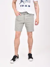 Bermuda de gabardina color oliva, con diseño de cinco bolsillos, cierre frontal con botón y detalles de desgaste sutiles.