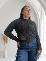 Sweater negro de tejido de punto con diseño de trenzas y roturas.