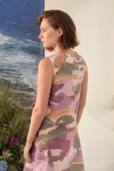 Top sin mangas de lino 100%, con diseño estampado multicolor en tonos rosado, verde y beige. Presenta cuello redondo y una cartera asimétrica con botones de madera frontales.