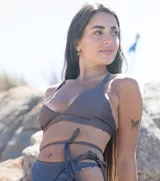 Top de bikini color crema, de corte triangular y breteles finos.