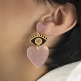 Aros colgantes con forma de corazón y ojo turco, color rosa con glitter y detalles dorados.