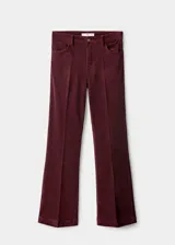 Jeans de pana tiro medio color bordó, con diseño flare y cinco bolsillos.