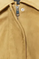 Chaqueta bomber de efecto ante en color tostado, con cuello solapa, manga larga y bolsillos laterales. Presenta un diseño con bajo acabado en pliegues que aporta volumen y cierre frontal con cremallera y botones a presión.