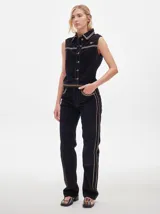 Pantalón de pana roja con corte holgado y tiro medio. Presenta una línea dorada a lo largo de la pierna.