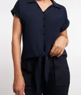 Blusa azul marino de viscosa con cuello solapa, abotonado delantero, mangas cortas con doblez y lazo en la parte baja.