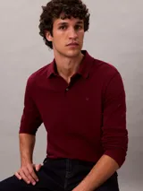 Chomba de manga larga Calvin Klein confeccionada en algodón supima, con cuello polo, cartera con botones y logo CK bordado en el pecho.