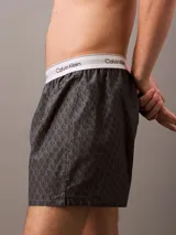Bóxer suelto de hombre Calvin Klein, confeccionado en popelín de algodón con estampado de logos en gris y cintura elástica blanca con logo.