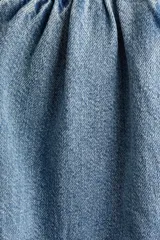 Pantalón oversized en denim de algodón rígido, con elástico revestido en la cintura, cierre con botón y bolsillos laterales discretos. Presenta un corte con piernas de diseño curvo y volumen.