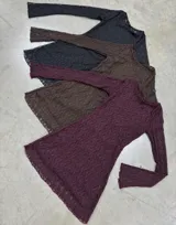 Vestido corto de encaje color marrón, con mangas largas acampanadas, cuello redondo y aberturas laterales. Incluye un cinturón de cuero sintético a tono con hebilla metálica.