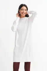 Vestido tipo sweater color blanco, de corte recto y largo hasta la rodilla, con cuello redondo y mangas largas.