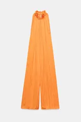 Mono largo satinado color naranja, de corte amplio con pierna ancha, cuello redondo y manga sisa, con detalle de tejido arrugado y cierre en la espalda.
