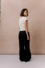Pantalón de jean negro de corte wide leg, tiro alto y con costura vertical frontal.