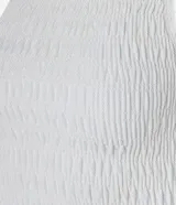 Musculosa blanca con cuello redondo, diseño con lastex y volado en el bajo.
